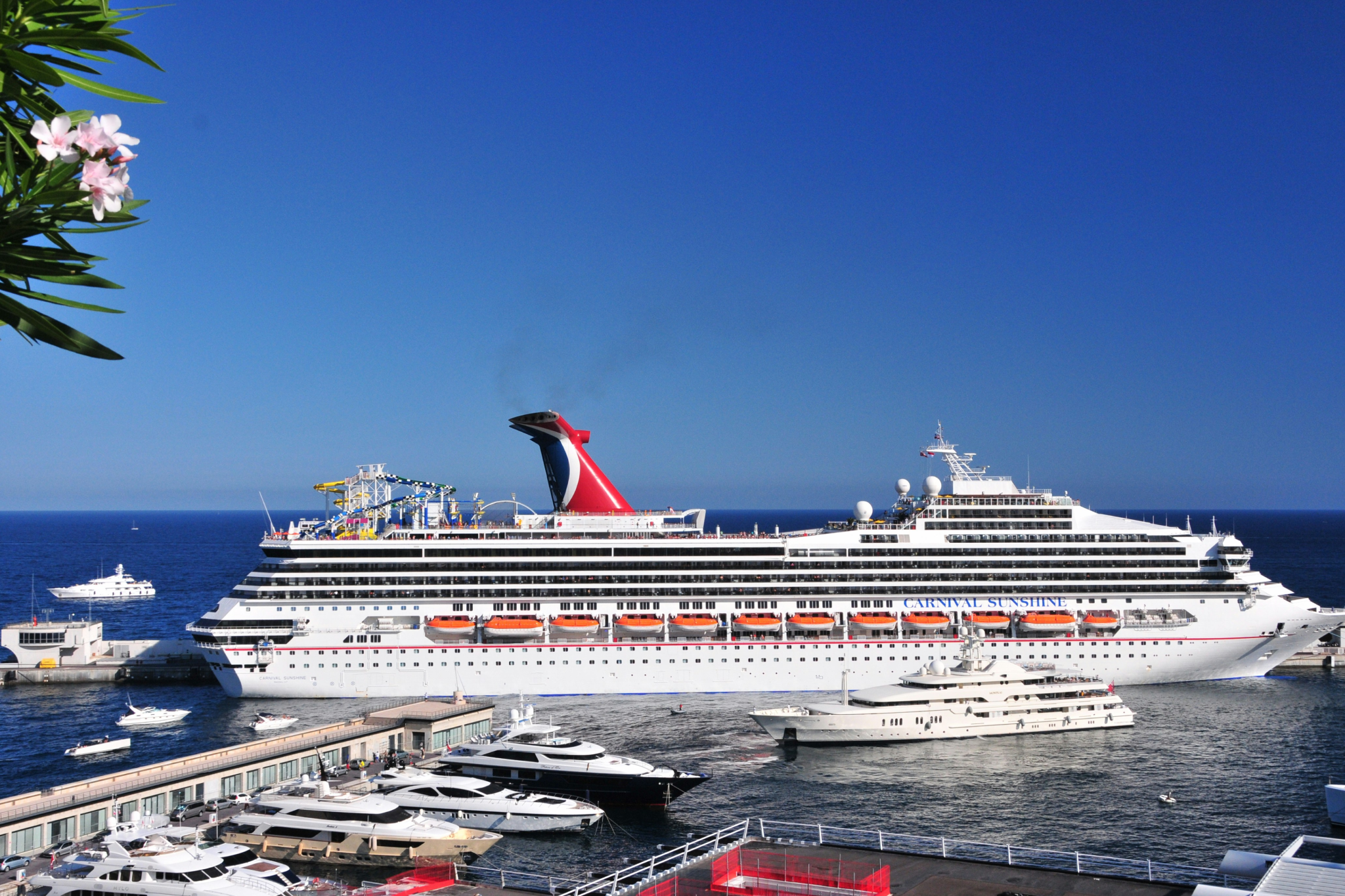 Carnival Cruise Line ship docked at a busy port with smaller yachts nearby, showcasing one of the Best Overall Cruise Lines in 2025 for lively, family-friendly vacations and entertainment-filled sailings.