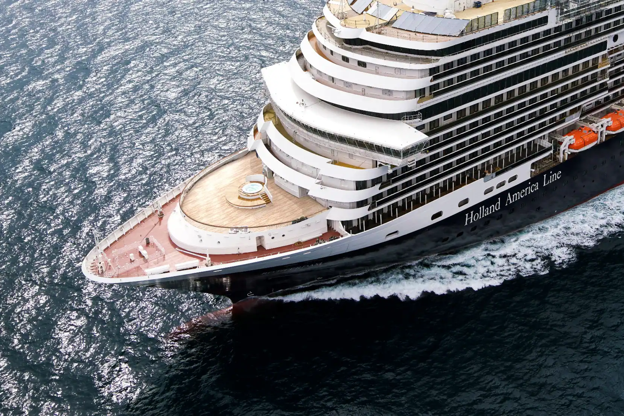 Aerial view of a Holland America Line cruise ship gliding through the ocean, representing one of the Best Overall Cruise Lines in 2025 with elegant design, calm onboard atmosphere, and destination-focused itineraries.
