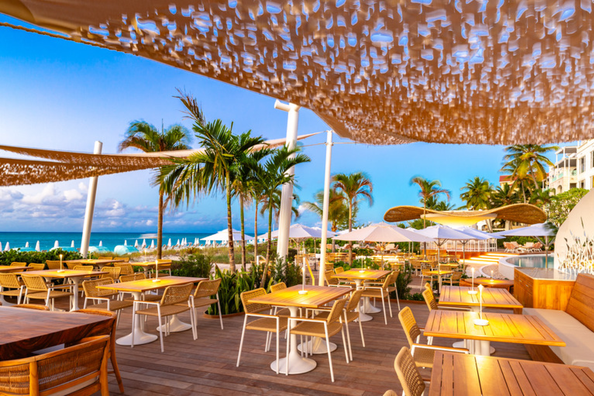 Beachfront dining terrace at The Palms Turks and Caicos with ocean views and tropical décor