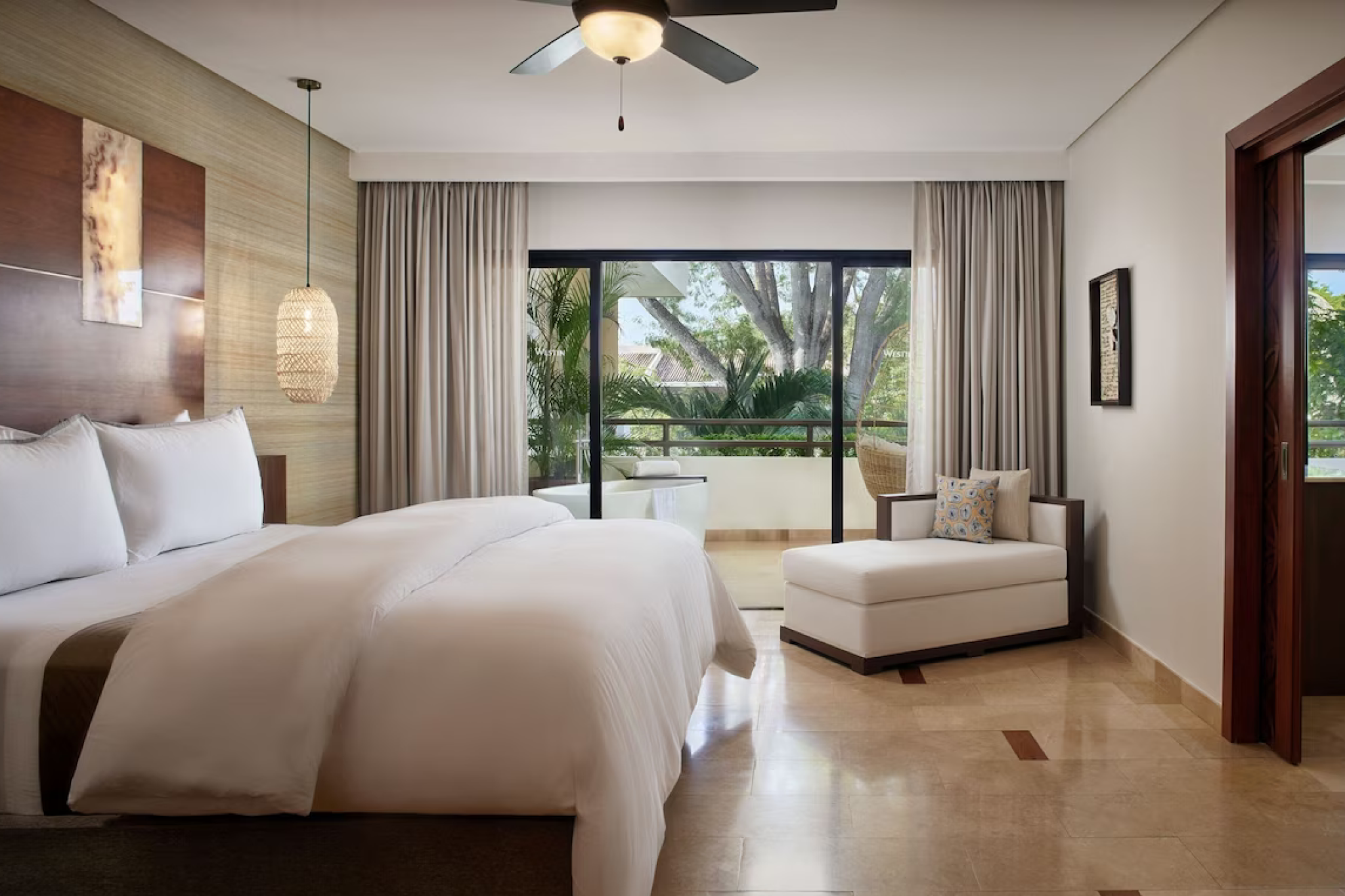 Spacious guest suite with balcony and garden views at The Westin Reserva Conchal.