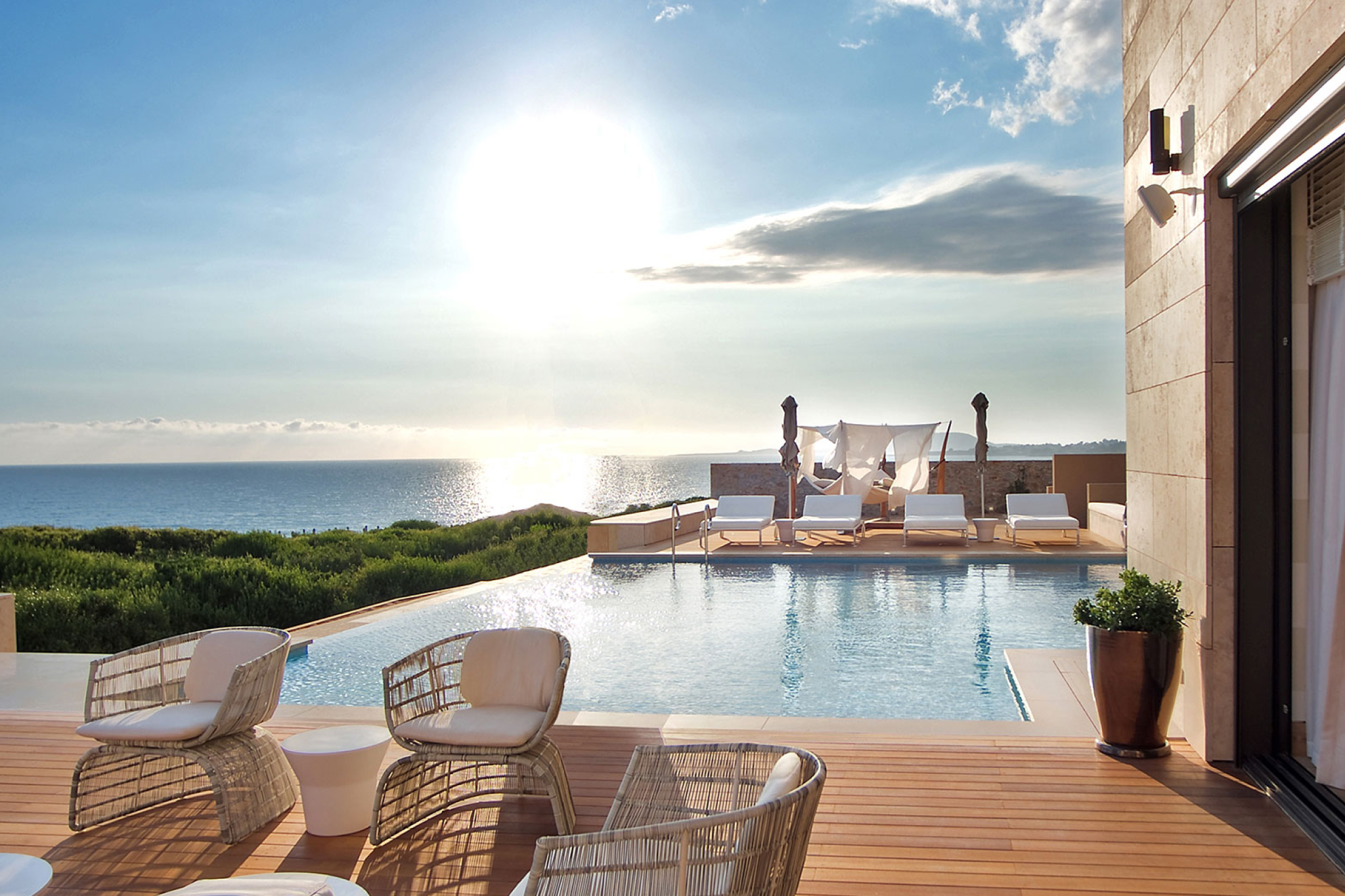 A serene oceanfront infinity pool at Costa Navarino with contemporary lounge beds facing the sunset over the Ionian Sea, capturing why this Peloponnese sanctuary ranks among the top beach resorts in Europe in 2025.