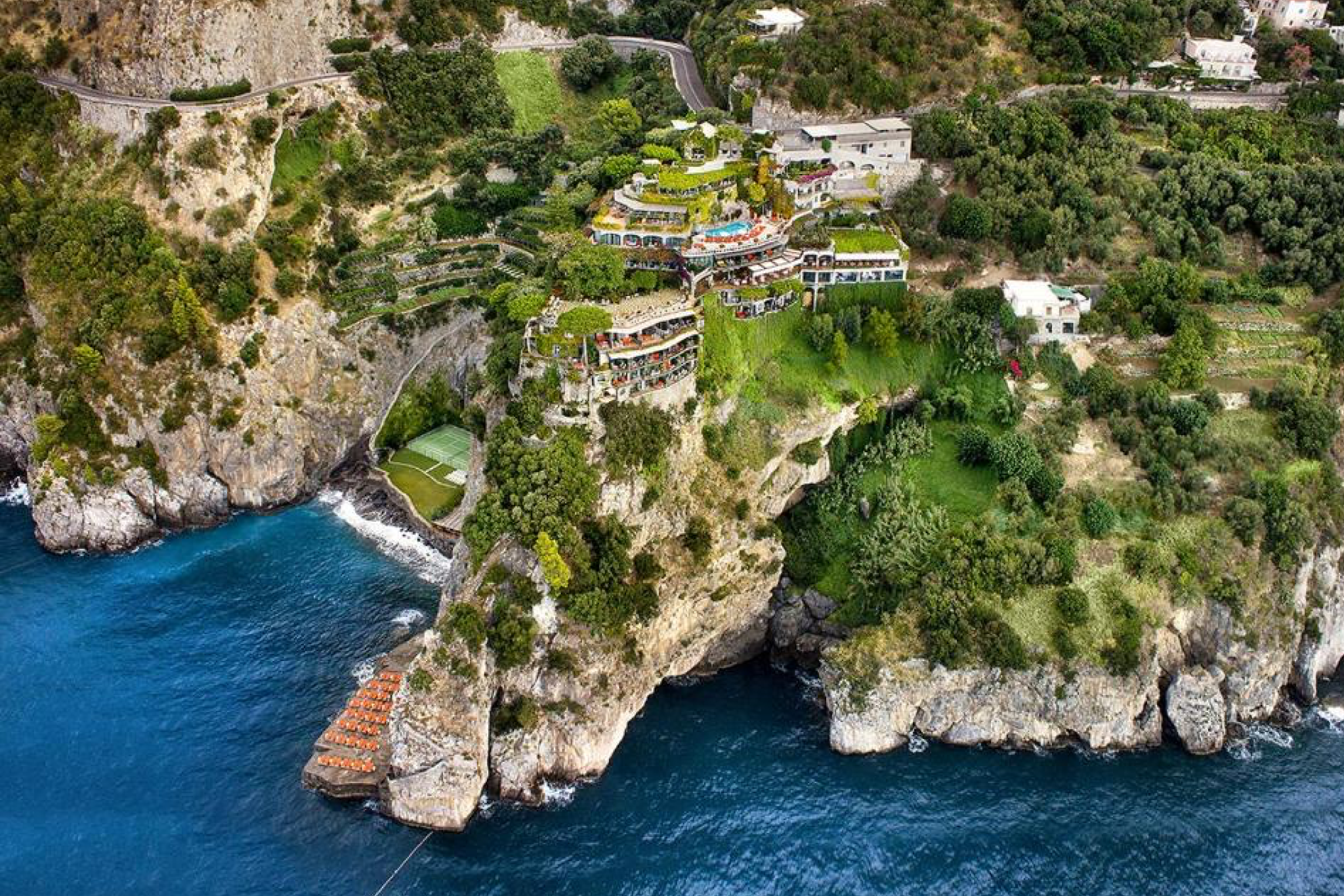 Dramatic cliffside terraces of Il San Pietro di Positano cascading toward the Amalfi Coast’s deep-blue shoreline, illustrating why this legendary property leads the list of the top beach resorts in Europe in 2025.