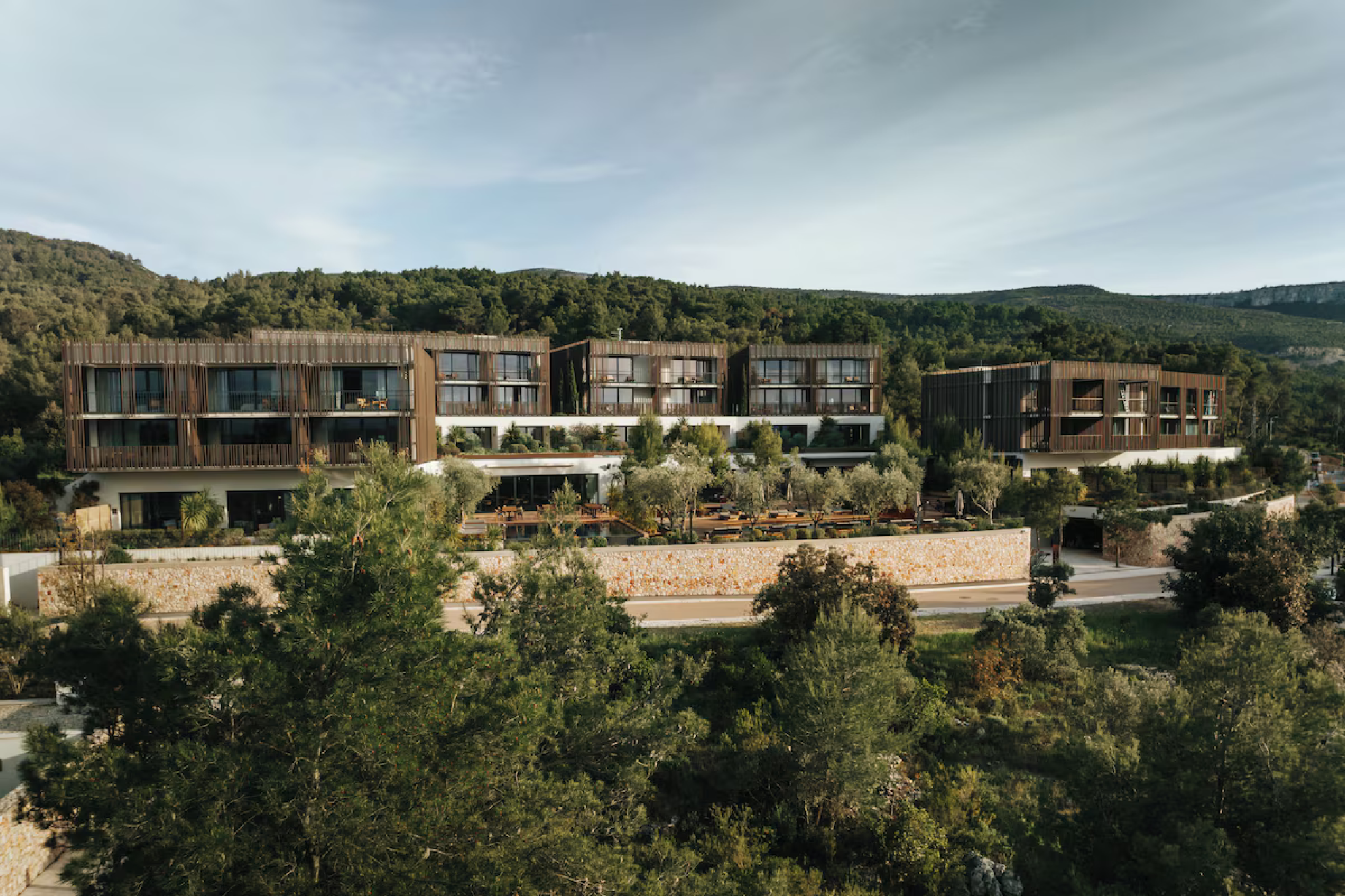 Modern, minimalist architecture surrounded by lush greenery at Maslina Resort on Hvar Island, presenting a refined wellness-focused hideaway listed among the top beach resorts in Europe in 2025.