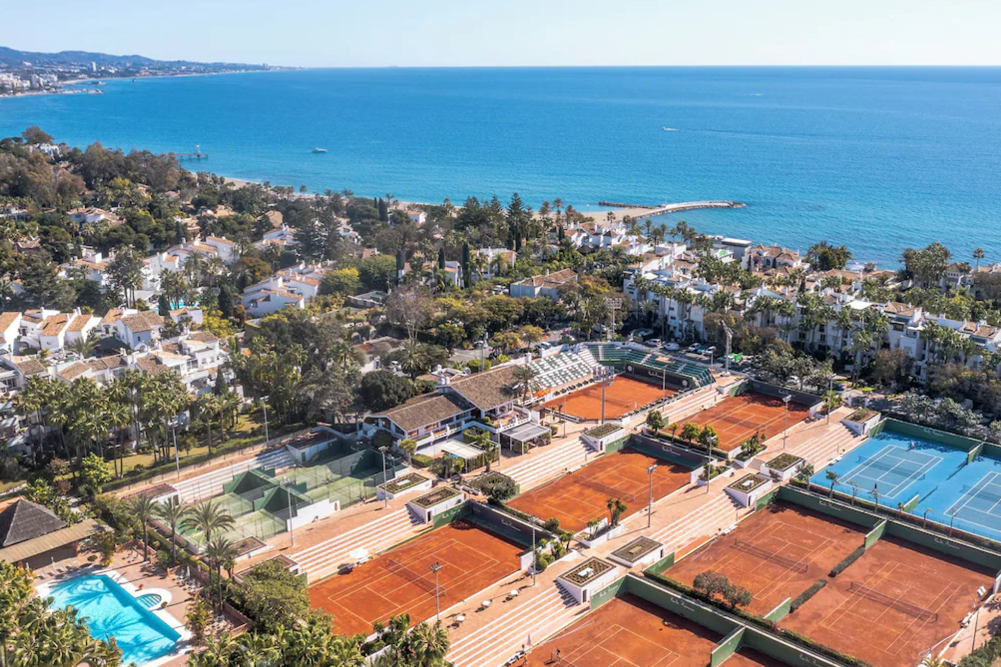 Aerial view of Nobu Hotel Marbella showcasing its clay tennis courts, lush Mediterranean landscape, and sweeping coastline, reflecting its status as one of the top beach resorts in Europe in 2025 for luxury and lifestyle travelers.