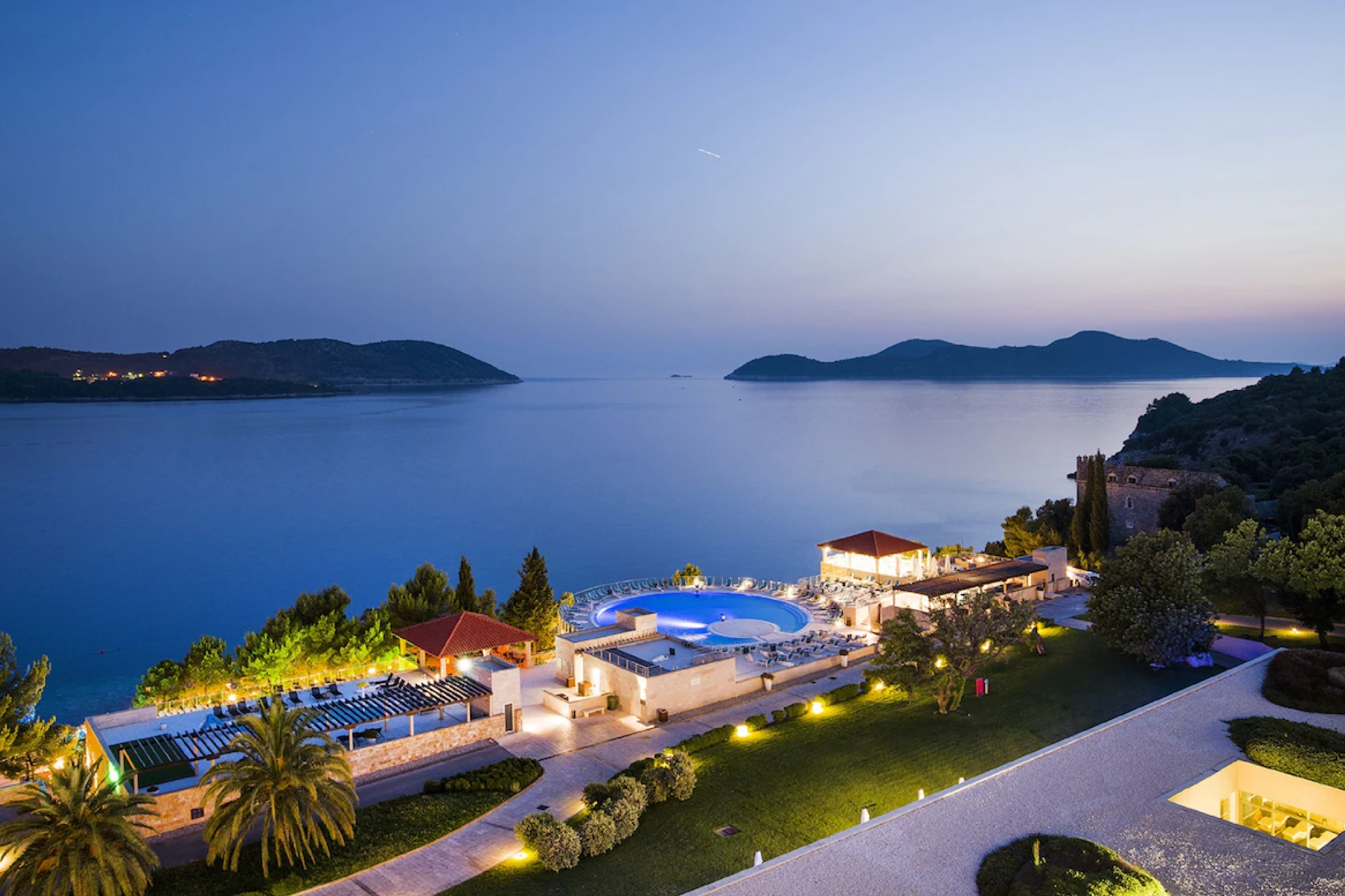A panoramic twilight view of Sun Gardens Dubrovnik overlooking the Adriatic Sea, featuring its illuminated pool terrace and surrounding islands—an elegant coastal retreat highlighted as one of the top beach resorts in Europe in 2025.