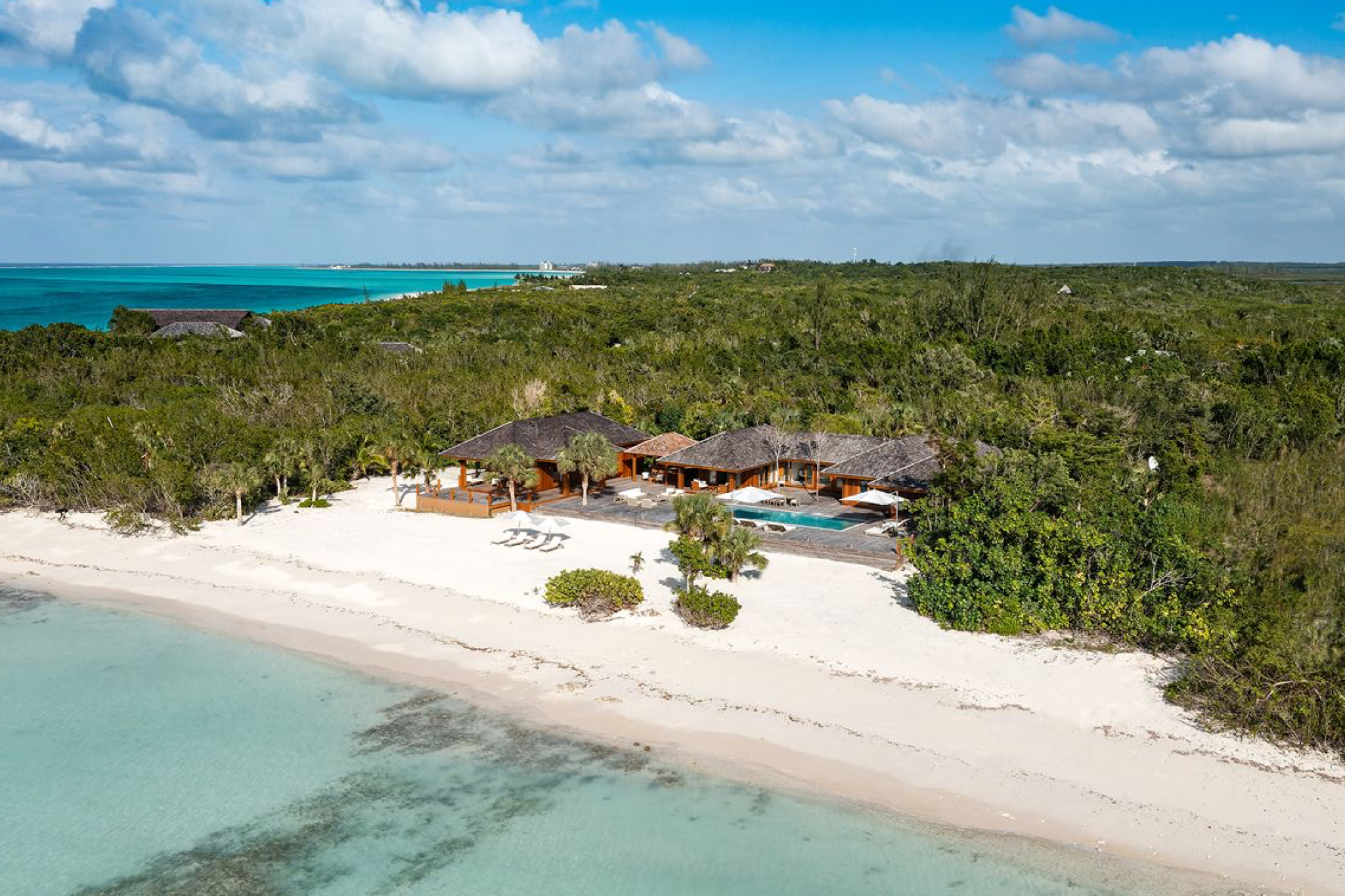A secluded beachfront villa at COMO Parrot Cay set against pristine white sand, crystal-clear turquoise water, and dense natural vegetation — a peaceful, wellness-focused escape ranked among the top resorts in the Caribbean Islands in 2025.