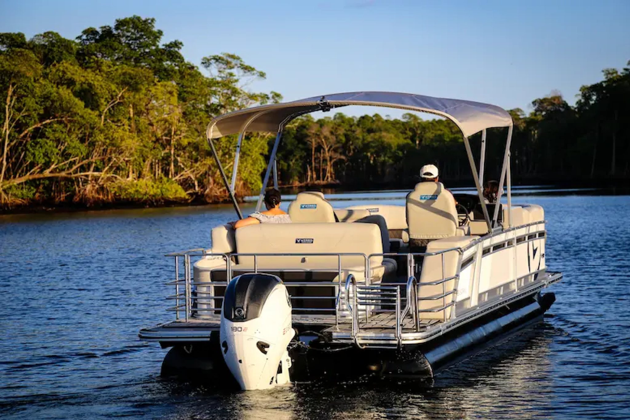 The V24 Electric Pontoon in use on a quiet inland waterway with passengers onboard, illustrating its suitability for eco-friendly cruising, group outings, and relaxed day trips.