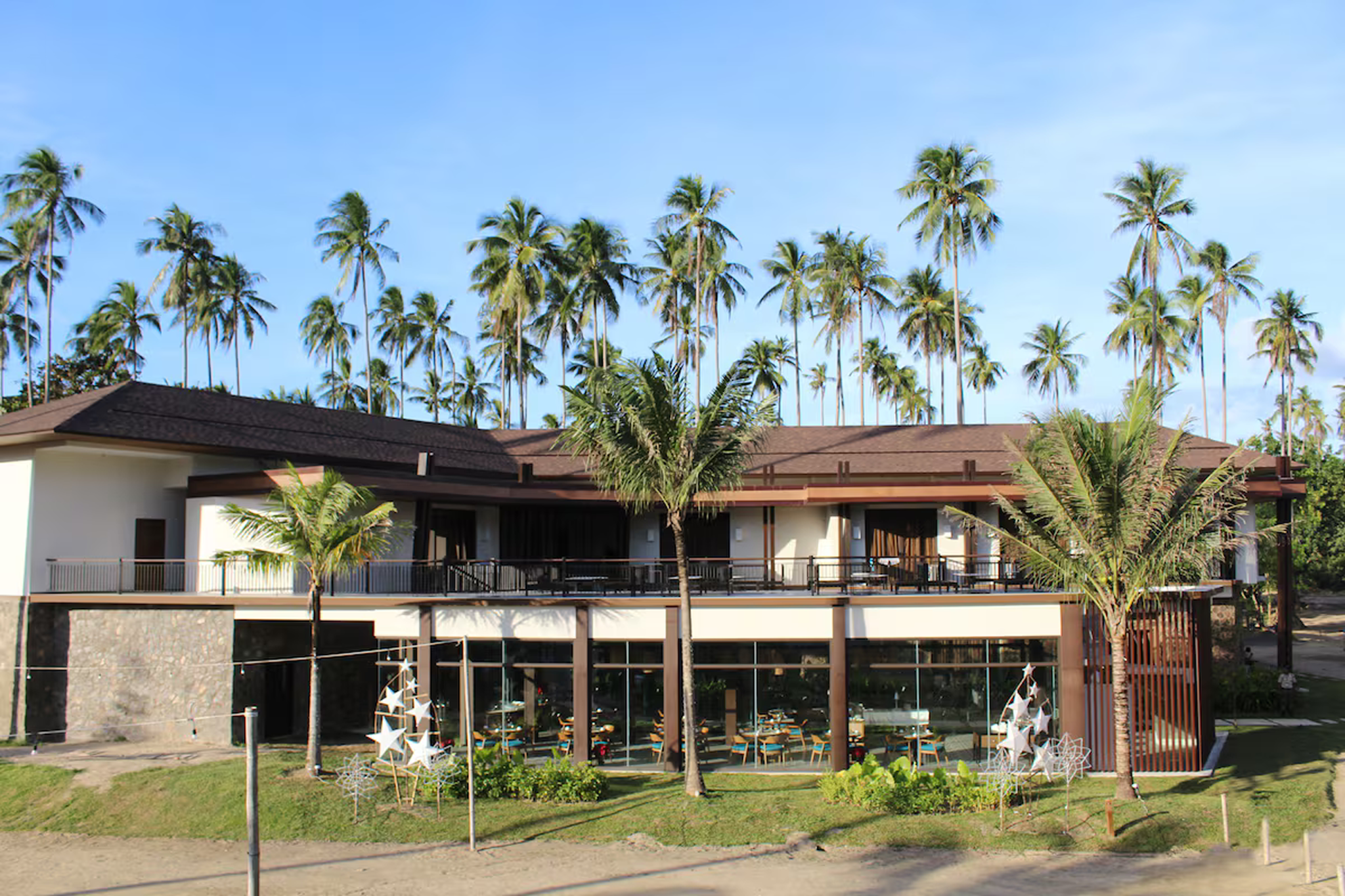 Minimalist beachfront hotel surrounded by palm trees — where to stay in El Nido, Palawan.