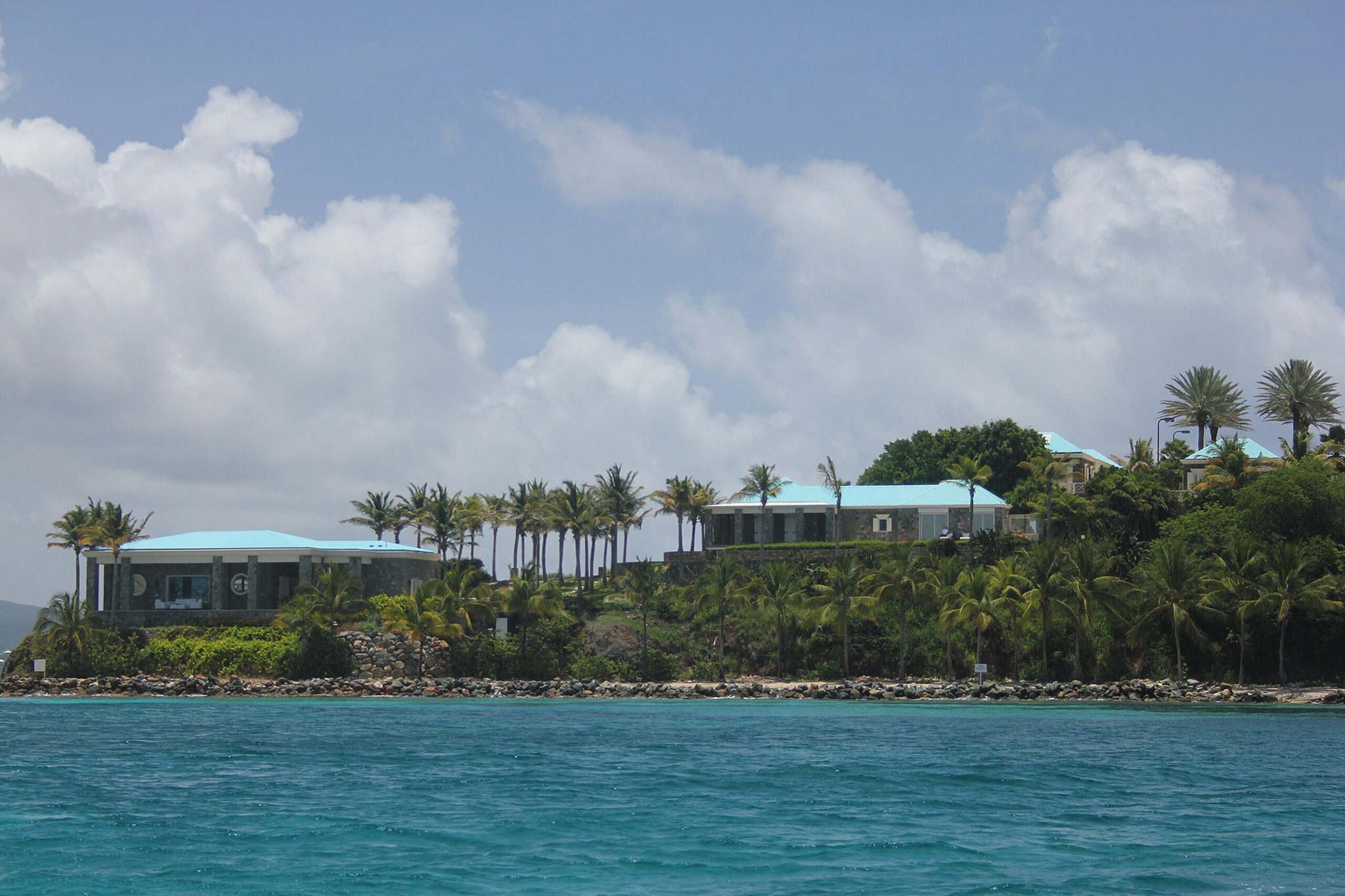 Aerial view of two small Caribbean islands with rocky shorelines and tropical vegetation, part of the U.S. Virgin Islands and recognized billionaire islands owned by Stephen Deckoff.