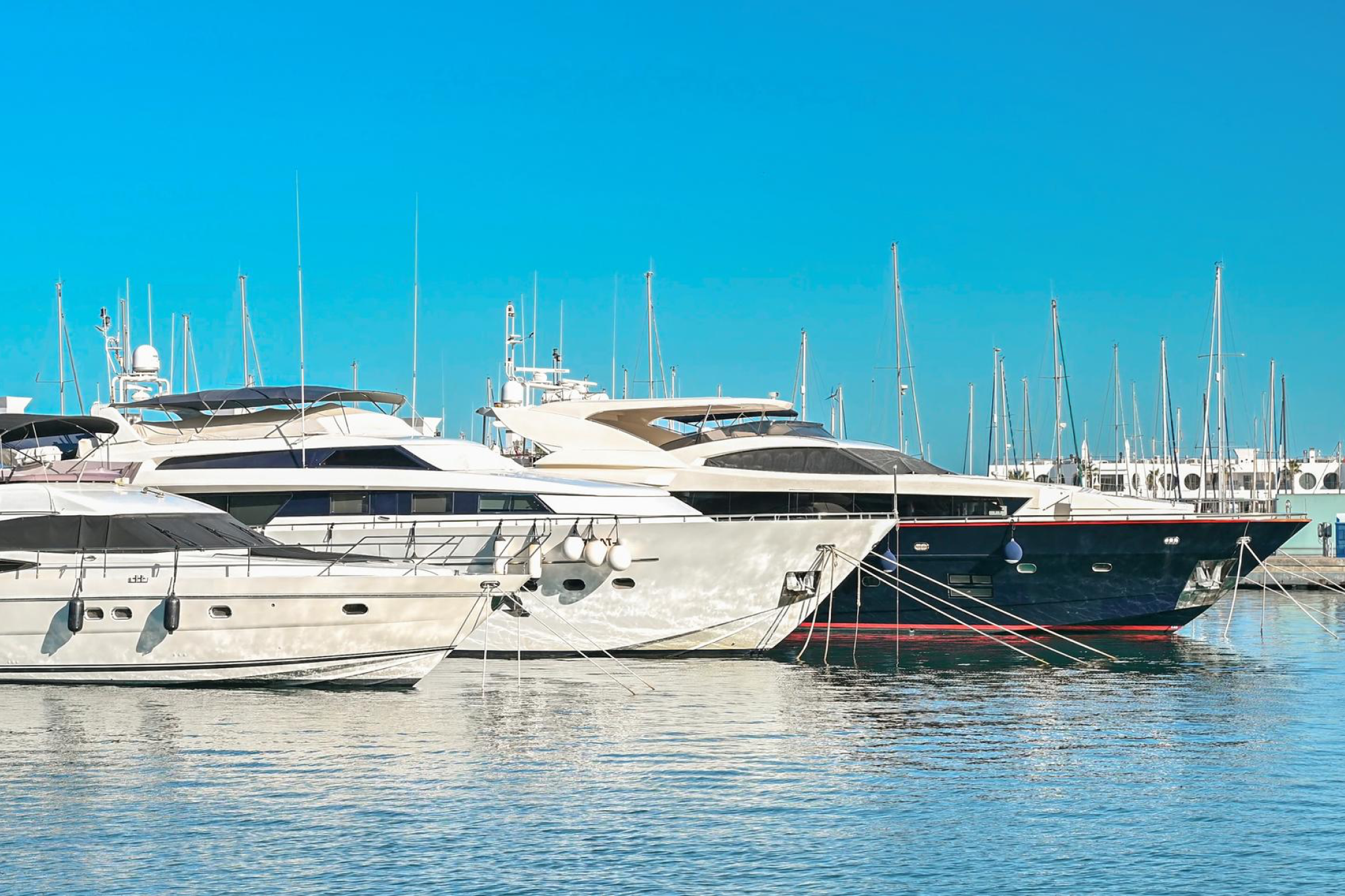 Yacht vs boat context with multiple yachts docked in a marina, highlighting their size and luxury features.